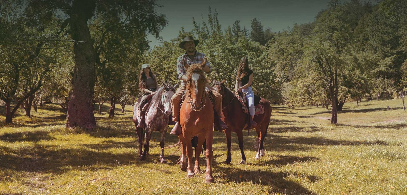 Jinetes en la chacra Wesley rodeados de bosque y pasto