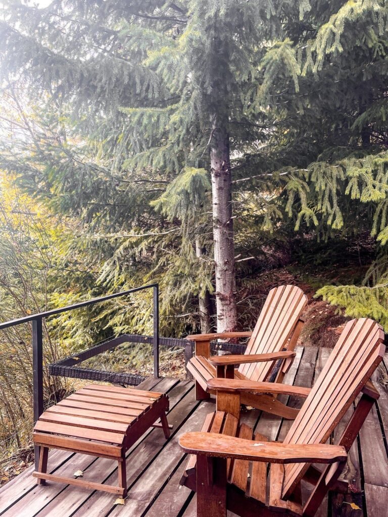 Deck with wooden lounge chairs among the trees